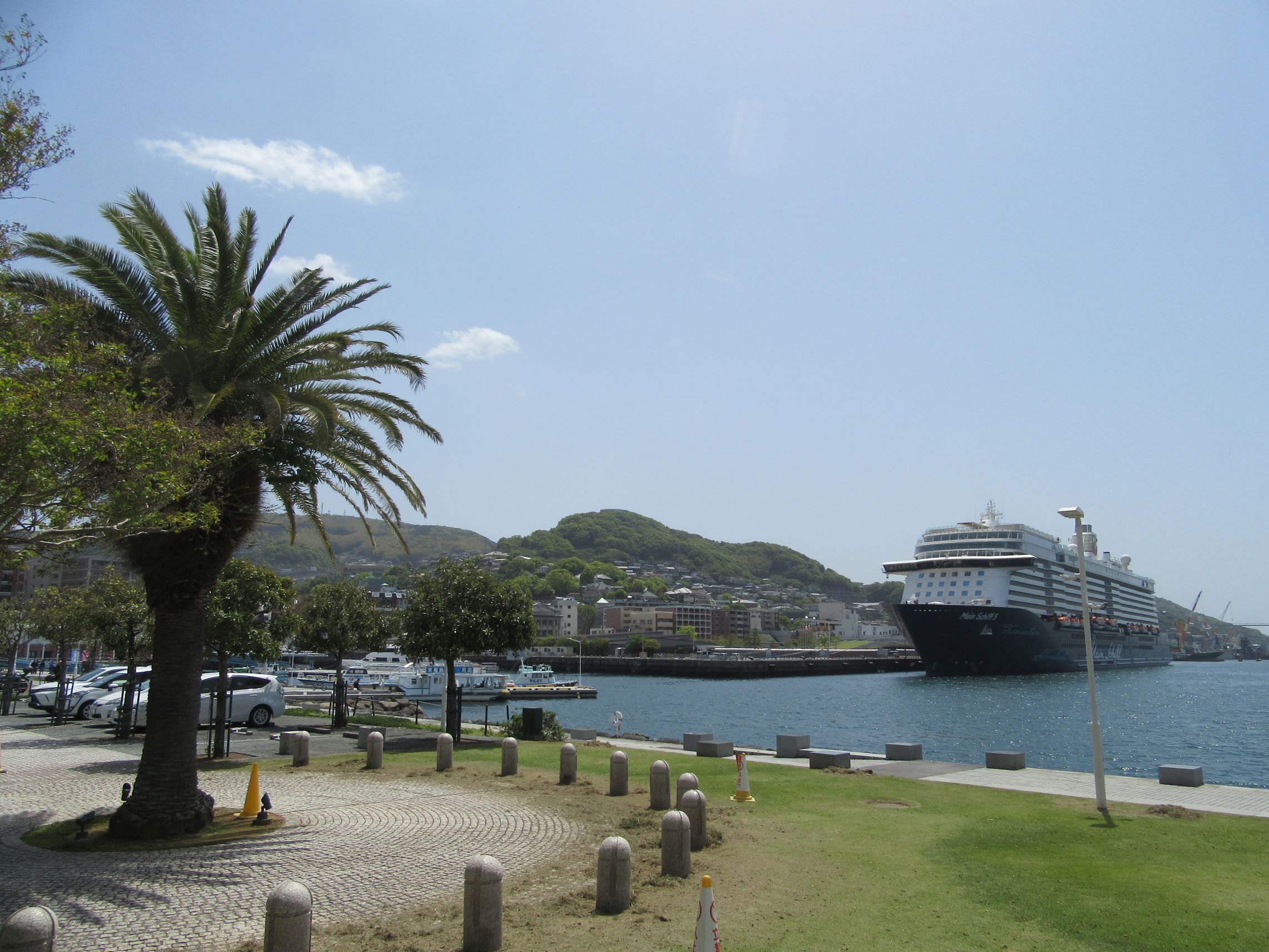 A park in Nagasaki by the sea, with a large cruise ship.
