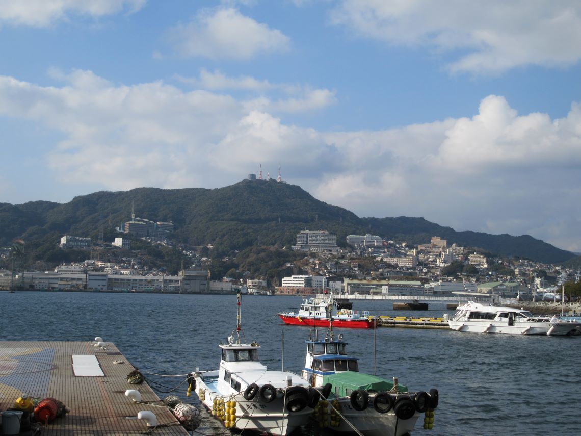 長崎市・長崎水辺の森公園付近で撮影した、海の上の船と稲佐山。