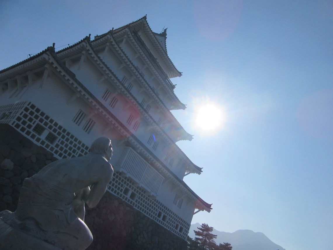 島原城で撮影した天守閣と、北村西望による彫刻作品『星空無限』が見上げる太陽。