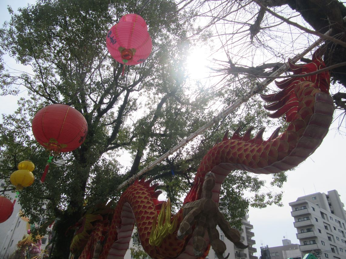 ランタンフェスティバル閉幕後の余韻が残る中央公園の赤い龍のオブジェと木漏れ日。