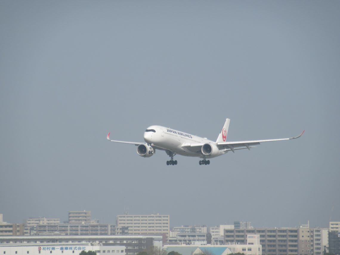 街なかにある福岡空港で着陸しようとしている日本航空（JAL）の飛行機。