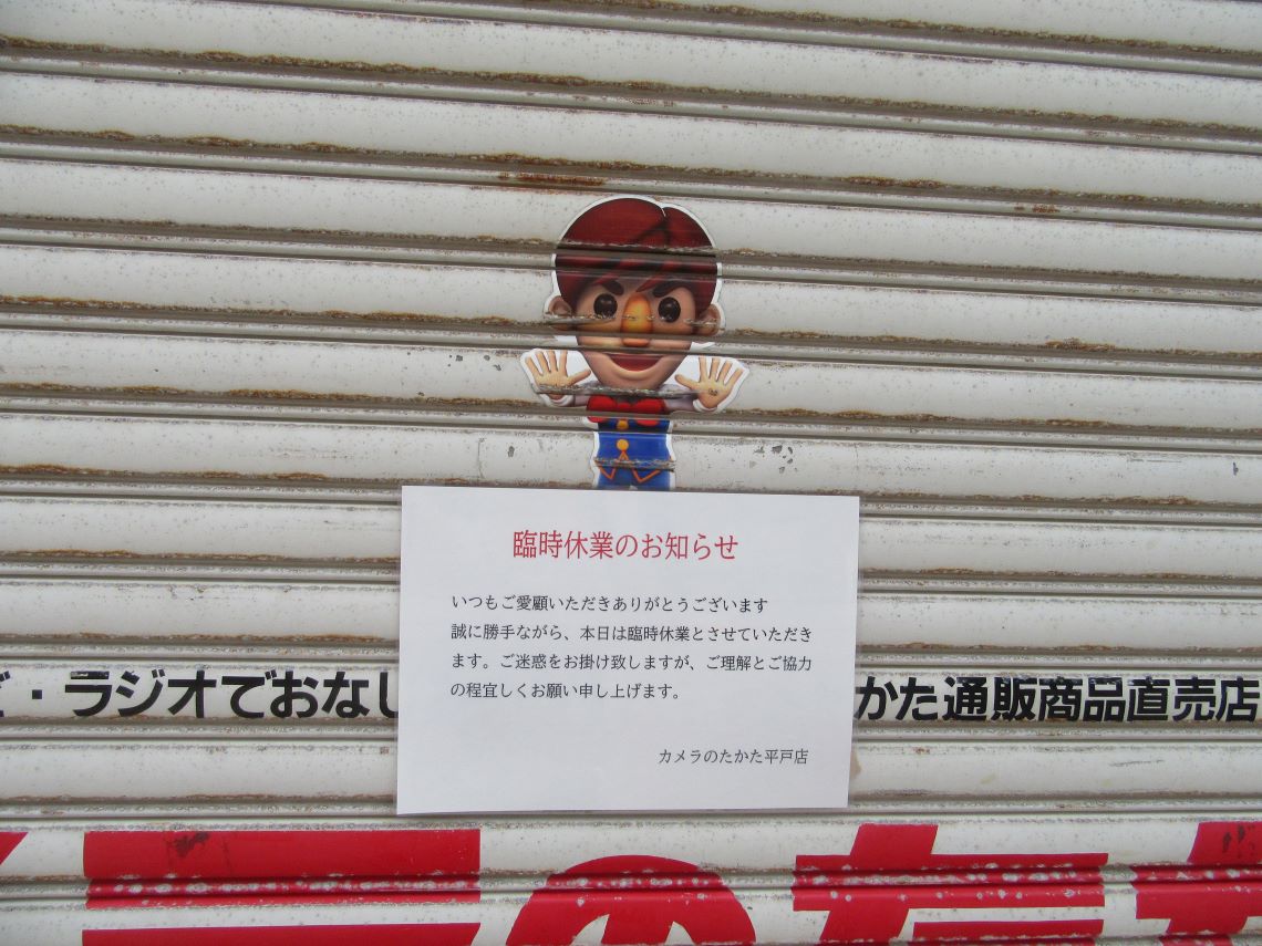 長崎県平戸市の市街地で撮影した、おなじみのキャラクターがいる『カメラのたかた』のシャッター。