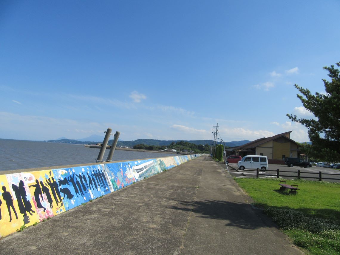 佐賀県藤津郡太良町にある道の駅太良の展望台付近にある、海沿いの絵と奥に見える道の駅の建物。