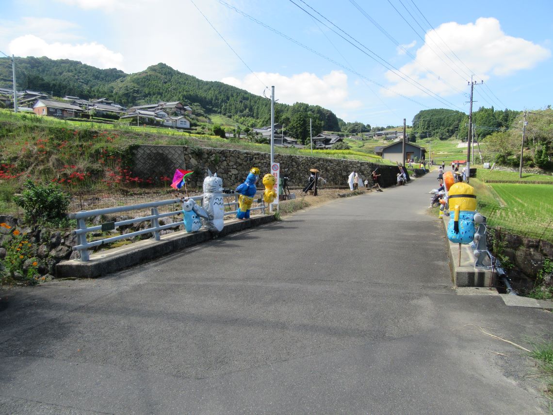 長崎県東彼杵郡波佐見町にある鬼木の棚田の、かかしたちと、田んぼと、彼岸花。